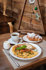 New Year's breakfast. Omelet with greens, croissant and coffee