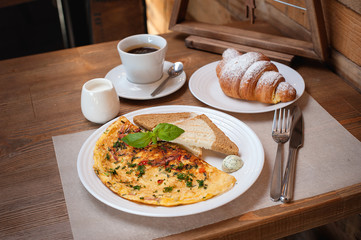 New Year's breakfast. Omelet with greens, croissant and coffee