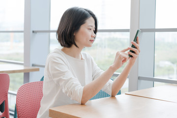 Obraz premium Asian female using smartphone
