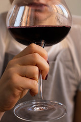 man drinking wine from a glass, a man in a defocus glass close-up.