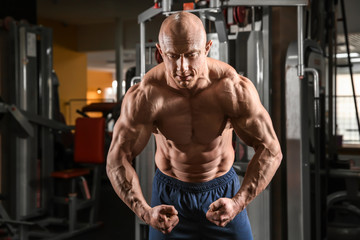 Obraz na płótnie Canvas Muscular man posing in gym