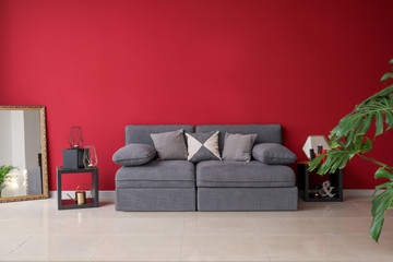 Stylish interior of living room with comfortable grey sofa