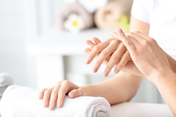 Fototapeta na wymiar Young woman getting massage of hands in beauty salon