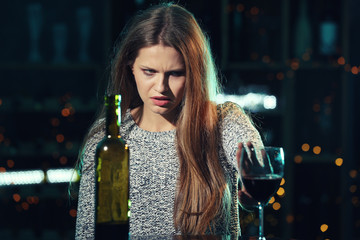 Young woman refusing to drink alcohol in bar