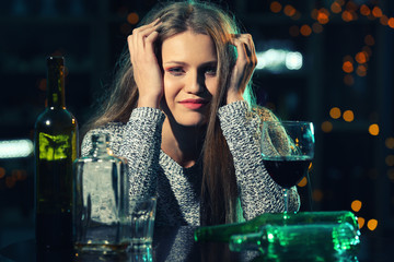 Young woman drinking alcohol in bar