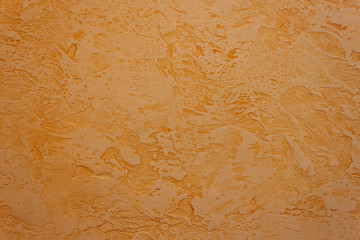 Texture of decorative plaster with a relief. Orange plaster. Abstract. Close-up.