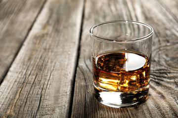 Glass of whiskey on wooden table