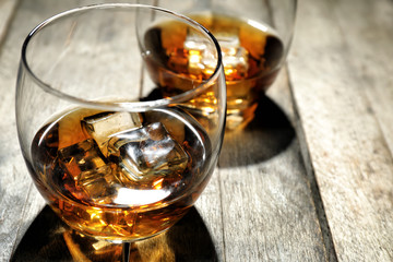 Glass of whiskey on wooden table, closeup