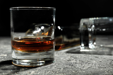 Glass of whiskey on grey table