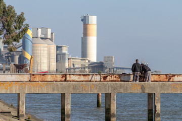 Obraz premium Dos operarios trabajando en los muelles en labores de mantenimiento