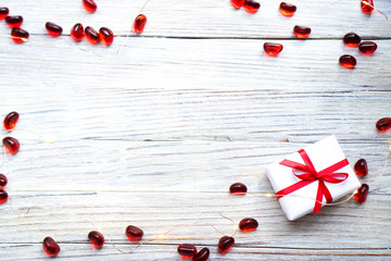 white gift box with red bow and hearts on white wooden background with gold bokeh, Valentine's day gift, tag I love you