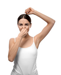 Fototapeta na wymiar Beautiful young woman feeling smell of sweat on white background. Concept of using deodorant