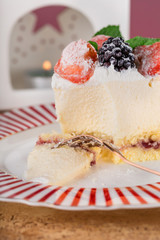 Close-up piece of cottage cheese cake with strawberries, blackberries and mint on a beautiful festive plate. Vertical.