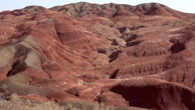 Panorama of the Red Mountains. The camera moves slowly along the panorama of the hills of red clay. Martian Landscape. The hills are carved with picturesque erosion