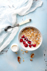 Bowl with tasty granola and yogurt on light table