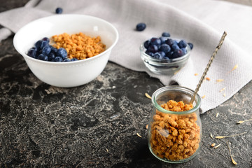 Jar with tasty granola on grunge table
