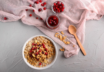 Bowl with tasty granola and yogurt on grey table