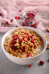 Bowl with tasty granola and yogurt on grey table