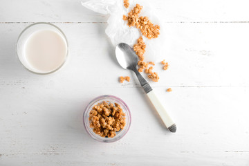 Tasty granola with yogurt on white wooden table