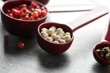 Measuring scoops with different pepper on table