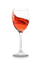 Glass with red splashing wine on white background