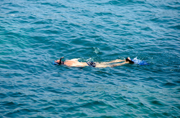 Tourist snorkeling swims in the sea water 