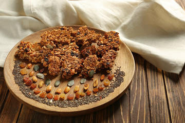 Plate with tasty baked granola on table