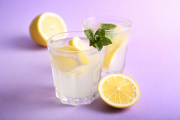 Glasses of fresh lemonade on color background