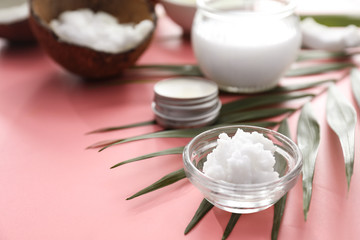 Bowl with coconut oil on color background