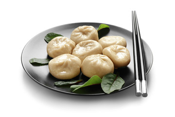 Plate with tasty Chinese dumplings on white background