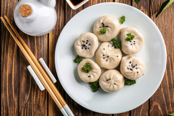 Plate with tasty Chinese dumplings on table