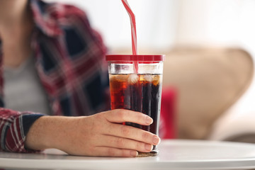 Woman with glass of cold soda at home