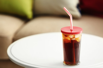 Glass of cold soda on table