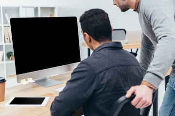Fototapeta premium cropped shot of business colleagues using desktop computer with blank screen in office