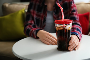 Woman with glass of cold soda at home