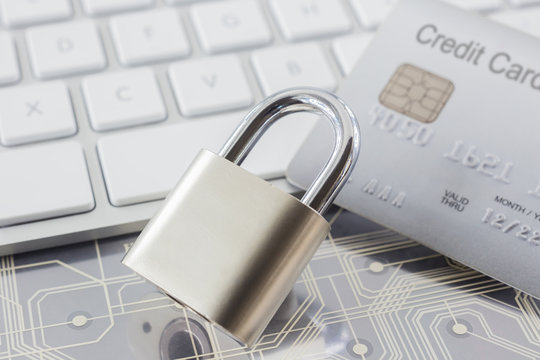 Padlock and credit card on keyboard and electronic circuits. - Powered by Adobe