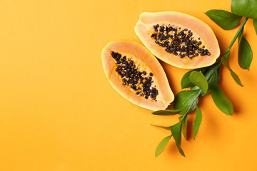 Tropical fruit and green leaves on color background