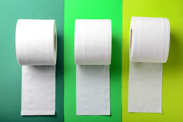 Rolls of toilet paper on color background