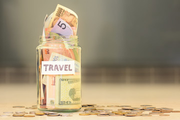 Travel funds jar full of savings with money from different countries