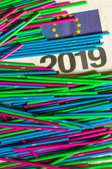 colorful plastic staws  on news paper sheet with 2019 and EU sign on it. ban act of plastic packaging in Europe 2019