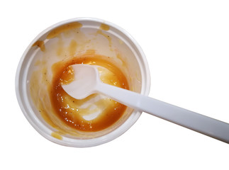 Finished and empty mashed potato in plastic round container with spoon, Isolated on white background.