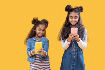 Positive cute girls texting to each other