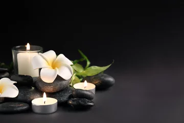 Foto auf Glas Beautiful spa composition with stones, candles and flowers on dark background © Pixel-Shot