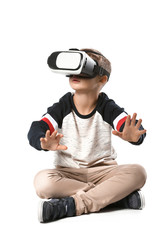 Cute boy with virtual reality glasses on white background