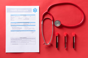 Medical insurance form with stethoscope and blood samples on color background. Health care concept