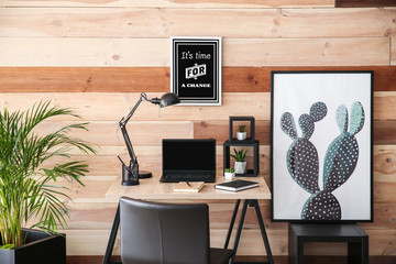 Stylish workplace with modern computer near wooden wall