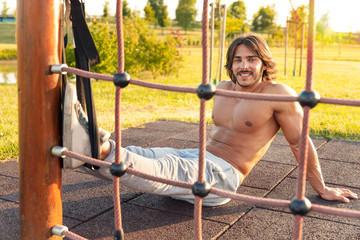 Man with six-pack smiling in the fitness park