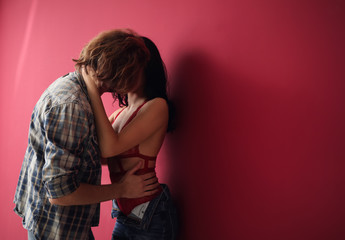 Passionate young couple near color wall