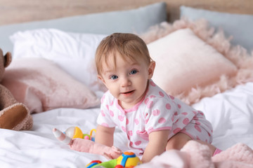 Portrait of cute little baby on bed at home