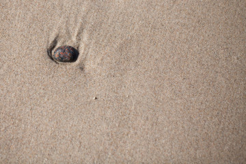 nostalgia - passing away, a stone lying on the beach washed by the sea.
